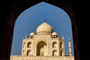 Taj Mahal incorniciato da un arco, cielo blu,