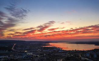 sbalorditivo rosso nuvole a tramonto al di sopra di il lago. foto