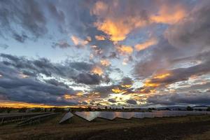 sorprendente colorato cielo dopo tramonto al di sopra di solare pannelli, con riflessione foto