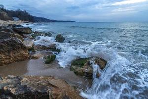 bellissimo movimento sfocatura mare onde al di sopra di il rocce e spruzzo di acqua di mare a mattina su il riva di il nero mare. foto