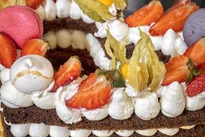 un' delizioso pezzo di torte con meringhe, crema, fragole, e macaron. vicino Visualizza foto