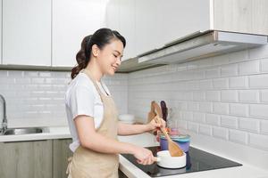 giovane attraente asiatico donna cuochi nel un' cucina, soffritto foto