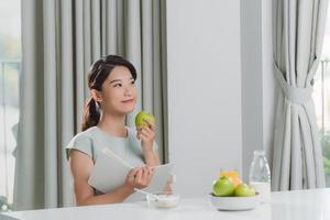 donna avendo prima colazione e lettura libro a casa foto