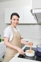 giovane donna che cucina in cucina foto