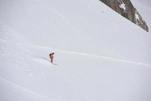 sciatore freeride che scia nella neve farinosa profonda foto