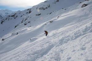 sciatore freeride che scia nella neve farinosa profonda foto