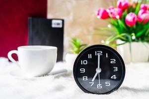 nero orologio e tazza di caffè foto