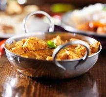 curry di pollo al burro indiano nel piatto balti con riso basmati