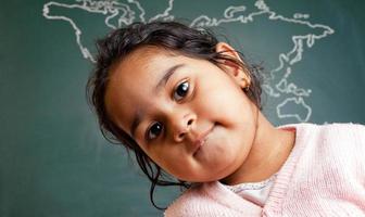 piccola ragazza prescolare indiana sveglia davanti alla mappa di mondo
