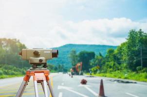 contagiri o teodolite per attrezzature da geometra con sfondo di un cantiere stradale foto