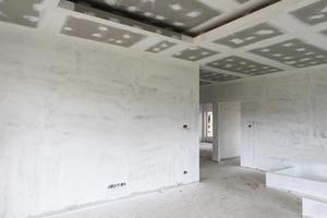 interno della stanza vuota con soffitto in cartongesso in cantiere foto