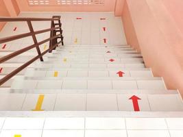 il le scale partire su e giù il edificio con rosso giallo frecce per sicurezza e ordine. foto