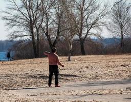 dnepr, Ucraina - 21.02.2022 un' di mezza età uomo fa ginnastica su il fiume banca. il concetto di un' salutare stile di vita e il combattimento contro linea il peso. foto