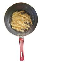 friggere francese patatine fritte nel un' padella con olio, su un' bianca sfondo, superiore Visualizza. foto