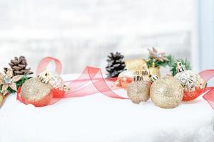 Natale di inverno - Natale palle con nastro su neve, inverno vacanze concetto. Natale rosso palle, d'oro palle, pino e i fiocchi di neve decorazioni nel neve sfondo foto