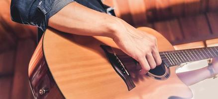 avvicinamento di il mani e dita di un' maschio musicista giocando un acustico chitarra.musicale chitarra strumento per ricreazione o rilassare passatempo passione concetto. foto