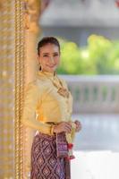 attraente donna tailandese in un antico abito tailandese tiene una ghirlanda fresca che rende omaggio al buddha per esprimere un desiderio sul tradizionale festival di songkran in tailandia foto