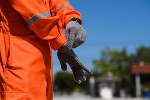 indossare costruzione sicurezza guanti avvicinamento foto. uomo indossare sicurezza guanti nel olio campo luogo foto