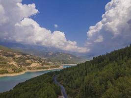 turchese acqua nel un' montagna foresta lago con pino alberi. aereo Visualizza di blu lago e verde foreste. Visualizza su il lago fra montagna foresta. al di sopra di cristallo chiaro montagna lago acqua. fresco acqua foto