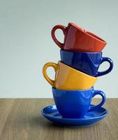 pila di colorato caffè tazze su tavolo foto