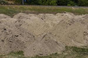 costruzione sabbia. montagna di sabbia su costruzione luogo. scavato terra. preparazione di fondazione per strada. foto