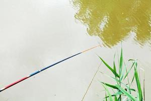 galleggiante galleggiante su superficie di fiume mentre pesca foto