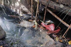 selettivamente messa a fuoco su spazzatura incollato nel fossi, quale può intasare e causa allagamento foto