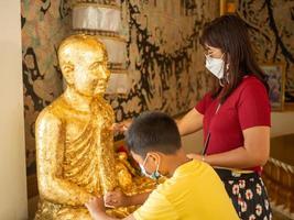 un' donna e un' ragazzo In piedi nel davanti di il Budda statua. foto