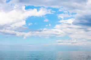 scenario di blu cielo con bianca nuvole al di sopra di calma mare foto