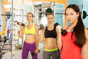 tre giovani donne nel fitness club foto