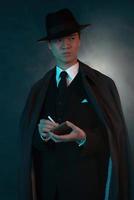 uomo di moda gangster asiatico 1940 retrò spaventoso. tenendo la scatola di sigarette. foto