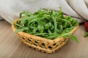 rucola nel un' cestino su di legno sfondo foto