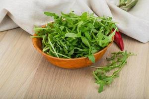 rucola nel un' ciotola su di legno sfondo foto