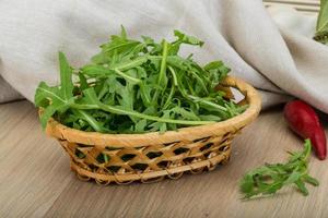 rucola nel un' cestino su di legno sfondo foto