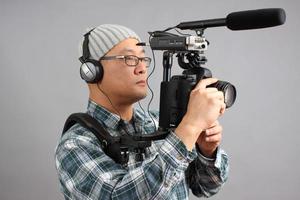 uomo con fotocamera reflex hd e apparecchiature audio foto