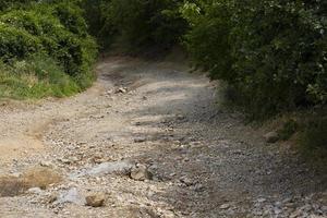 cattivo strada nel montagnoso la zona, roccioso strada lavato su dopo pesante piovere, fuori strada. foto