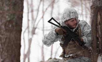 inverno guerra nel il artico montagne. operazione nel freddo condizioni.soldato nel inverno mimetizzato uniforme nel moderno guerra esercito su un' neve giorno su foresta campo di battaglia con un' fucile. selettivo messa a fuoco foto