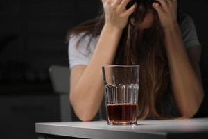 femmina medico è depresso. solitario femmina bevitore alcolizzato soffrire a partire dal alcool dipendenza avendo problema, alcolismo concetto. il conseguenze di un' pandemia e auto-isolamento foto