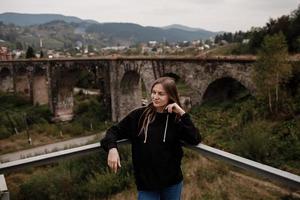 donna turista gode in viaggio per storico posti nel Ucraina, viadotto nel il montagna ricorrere villaggio di vorochta foto