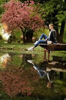 ritratto di bellissimo donna vicino un' di legno ponte di il lago a soleggiato giorno. bellissimo ragazza su un' di legno ponte su un' lago foto