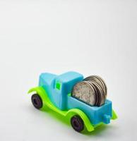 argento monete impilati su un' blu verde camion. bianca sfondo concetto auto assicurazione politica finanziario attività commerciale foto