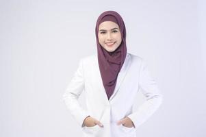 bellissimo musulmano attività commerciale donna indossare bianca completo da uomo con hijab nel studio foto