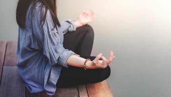 giovane donna pratiche yoga nel all'aperto. seduta nel loto posizione. scollegato vita e mentale Salute concetto. sukhasana posizione e Meditare foto