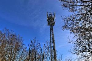 elettrico antenna e comunicazione trasmettitore Torre nel un' settentrionale europeo paesaggio contro un' blu cielo foto