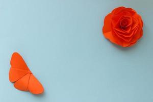 origami carta sfondo con arancia farfalla e fiore. origami composizione con posto per il tuo design. carta mestiere foto