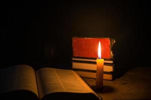 leggero candela con santo Bibbia e attraversare o crocifisso su vecchio di legno sfondo nel chiesa.a lume di candela e Aperto libro su Vintage ▾ legna tavolo cristianesimo studia e lettura nel concetto.casa di Cristo religione foto