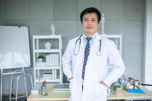 asiatico medico con stetoscopio nel ufficio, assistenza sanitaria e medicina concetto. foto