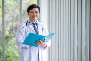 asiatico medico con stetoscopio e documento cartella, assistenza sanitaria e medicina concetto. foto