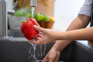 lavaggio verdure. un' donna nel il cucina. foto