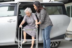 badante figlia aiuta e sostiene asiatica anziana o anziana signora paziente prepararsi a uscire dalla sua auto. foto